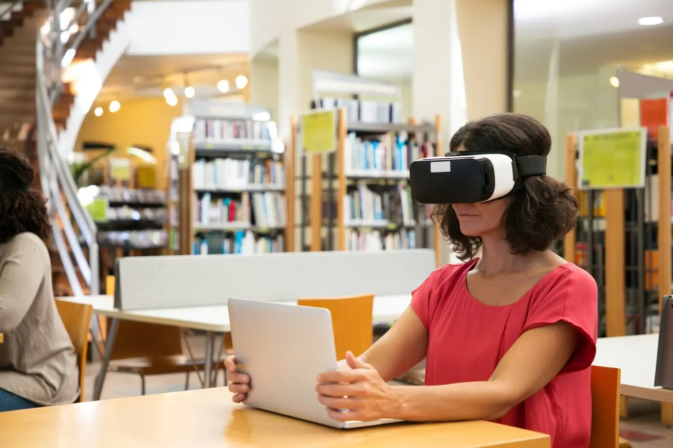 Eine Frau nutzt einen VR-Simulator in einer Bibliothek.