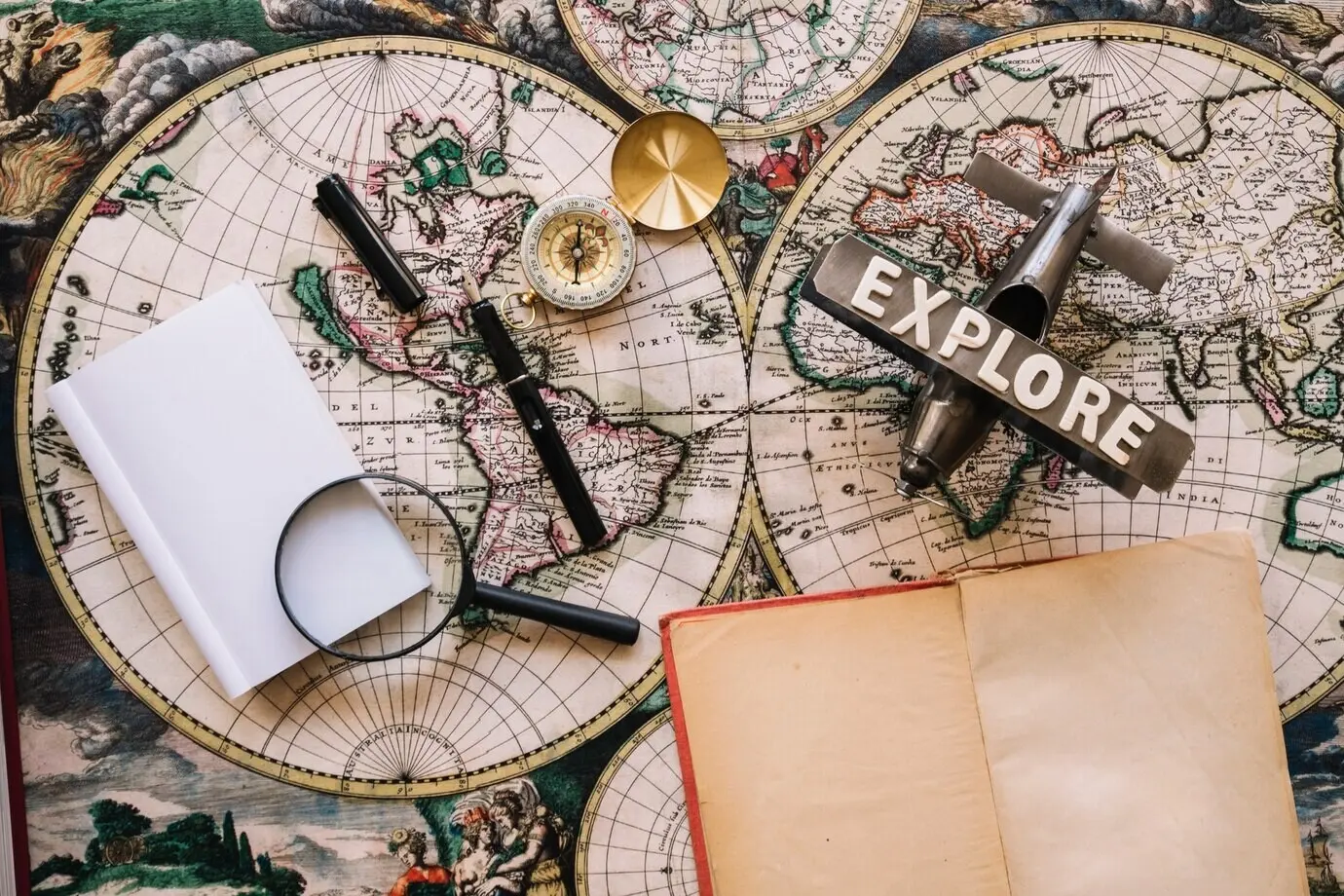 Aufgeschlagenes Notizbuch in der Nähe von Reiseutensilien